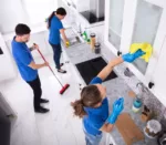 Group,Of,Young,Janitors,In,Uniform,Cleaning,Kitchen,At,Home